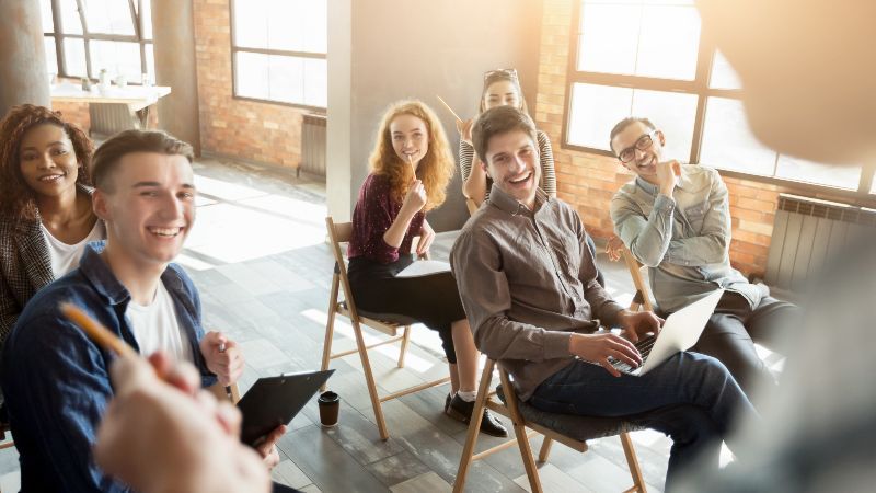 Eine Gruppe junger Personen nehmen begeistert an einem Workshop teil.