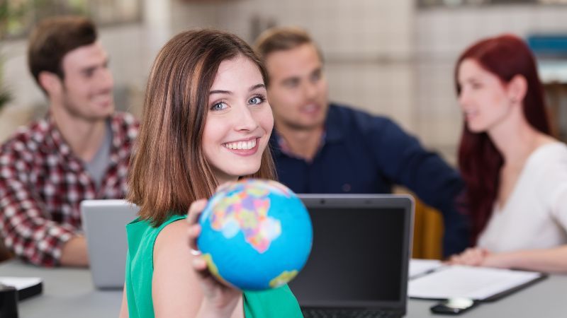 Junge Frau mit Globus in der Hand