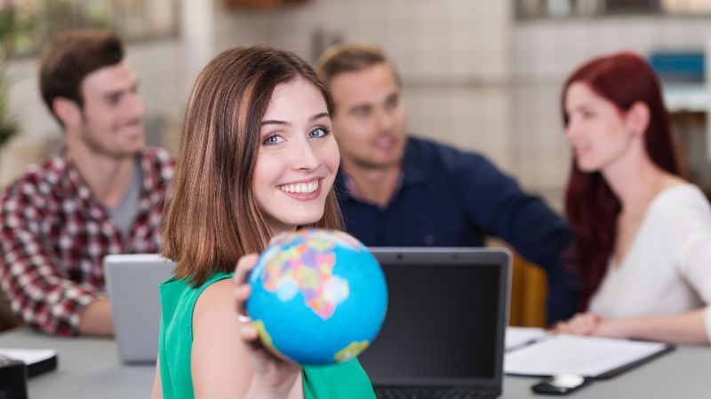 Junge Frau mit Globus in der Hand