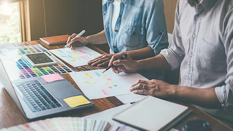Zwei Personen arbeiten zusammen an einem Schreibtisch