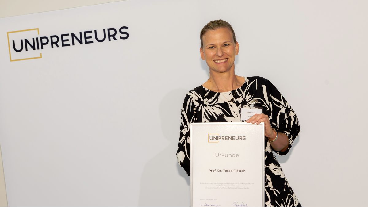 Prof. Dr. Tessa Flatten mit Verleihungsurkunde von Unipreneurs